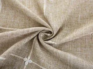 Close-up of linen-textured fabric with white grid embroidery and delicate flower details