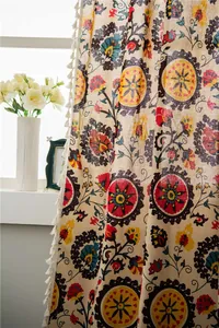 Detail of bohemian cotton linen curtain with floral mandala patterns and white tassels