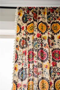 Detailed shot of bohemian sunflower curtains with red floral patterns and white fringe edge