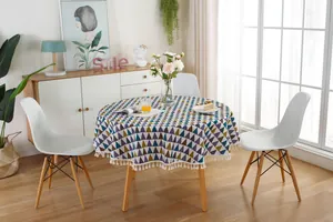 Detail of round nordic tablecloth with geometric triangles and white cotton fringe tassels