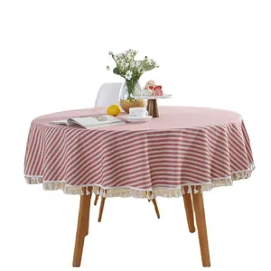 Red and white striped round tablecloth with fringe tassels on a cozy wooden table