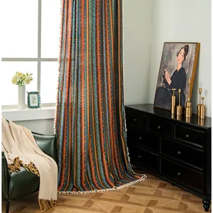 Detail of bohemian cotton linen curtain with colorful stripes and white tassel fringe