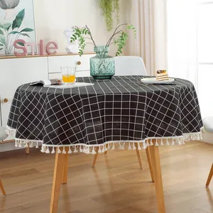 Detail of round black and white grid tablecloth featuring elegant tassel fringe edges