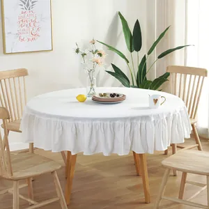 Close-up of white round tablecloth featuring detailed ruffled edges and natural linen texture
