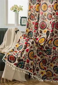 Detail of bohemian floral cotton linen curtain with ethnic print and white fringe trim