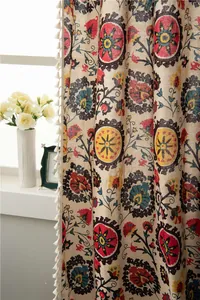 Detail of bohemian floral cotton linen curtain with white pom-pom tassel trim decoration