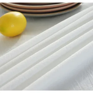 Detailed macro view of high-quality white linen tablecloth with soft natural textures