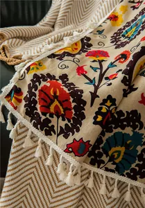 Detail of bohemian sunflower printed cotton linen throw with elegant cream fringe edges