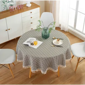 Detailed view of grey and white checkered round tablecloth with white fringe tassels