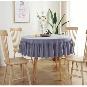 Detail of light purple round tablecloth featuring elegant ruffled edges and draped hem
