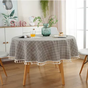 Close-up of grey plaid cotton linen tablecloth with elegant cream tassel fringe details