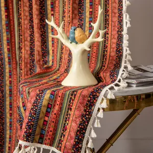 Bohemian cotton linen curtain with colorful stripes and white tassels on a table
