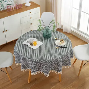 Detail of grey arrow pattern on round tablecloth with cotton linen tassels