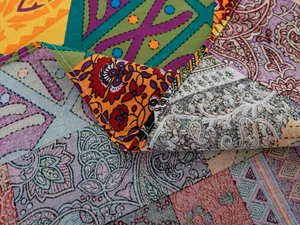 Dettaglio del tessuto in lino boho con patchwork paisley colorato e cuciture sui bordi
