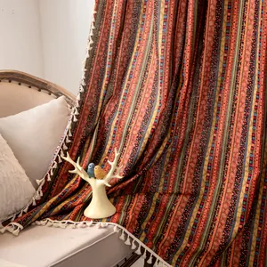 Detail of bohemian curtain with colorful geometric stripes and white cotton fringe tassels