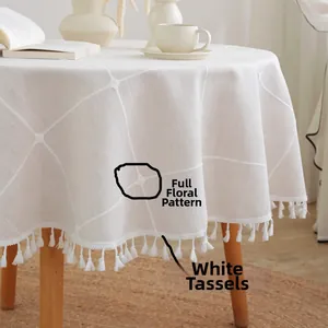 Detailed view of white round tablecloth featuring grid patterns and elegant white tassels