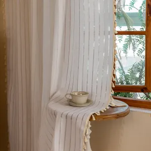 Detailed texture of cotton linen striped curtain with boho tassels in soft sunlight