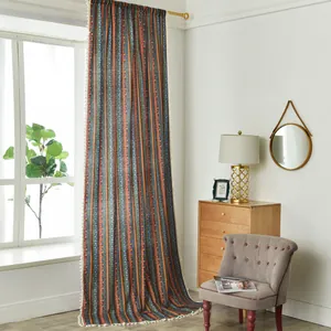 Detail of colorful striped cotton linen curtain with bohemian ethnic patterns and white tassels