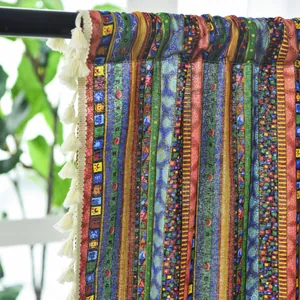 Detail of colorful bohemian striped curtains with geometric patterns and white tassels