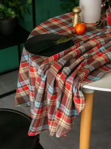 Detailaufnahme der braun-roten karierten Tischdecke mit festlicher Tischdekoration