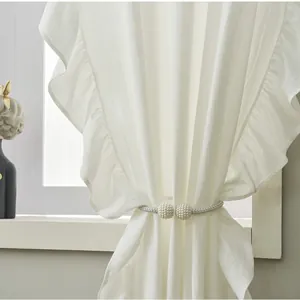 Close-up of elegant double white pearl curtain tieback with silver braided rope