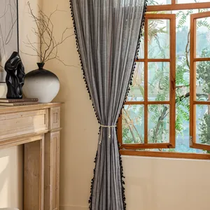 Detail of Nordic linen curtain with black vertical stripes and decorative tassels