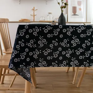 Detailed close-up of blue linen tablecloth with white daisy pattern and stitched edges