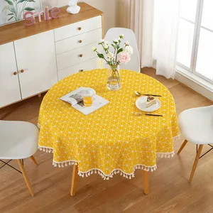 Detail of yellow round tablecloth with white triangle pattern and tassel edge fringe