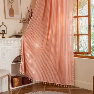 Detailed texture of cotton linen striped curtain with elegant tassel fringe in soft peach