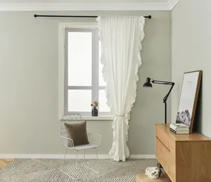 Close-up detail of white double-layered ruffled curtains with elegant pleated edges