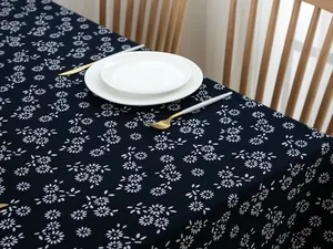 Detailed texture of navy floral cotton linen tablecloth with elegant wood table setting