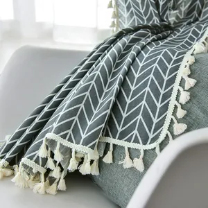 Detail of grey geometric cotton linen fabric with decorative white fringe tassels