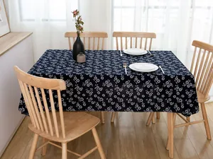 Detail of blue batik cotton linen tablecloth with white daisy pattern on a wooden table