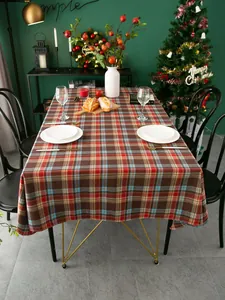 Detail van rood-bruin geruit kersttafelkleed in een sfeervolle rustieke tafelsetting