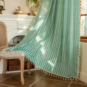 Mint green striped sheer curtain with white fringe tassel edges in a vintage living room