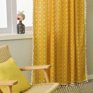Close-up of yellow geometric cotton linen curtain with elegant off-white tassel edges