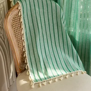 Detailed view of Nordic cotton linen curtain fabric with green stripes and fringe trim