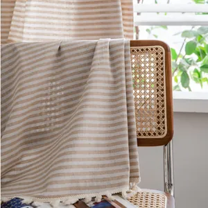 Nordic minimalist cotton linen striped curtain with tassel trim hanging on a chair