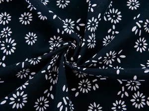 Close-up of cotton linen fabric with white daisy patterns and textured weaving detail