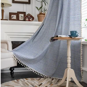 Blue and white striped linen curtain with elegant tassel trim in a bright home setting