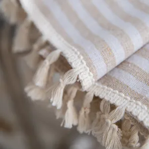 Macro shot of striped cotton linen fabric with tassel edges and detailed woven texture