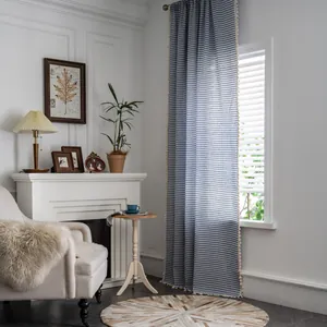 Detail of blue striped linen curtain featuring delicate cream tassel fringe trim