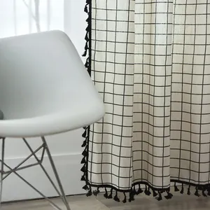 Detail of grey and white geometric cotton linen curtain with black tassel fringe accents