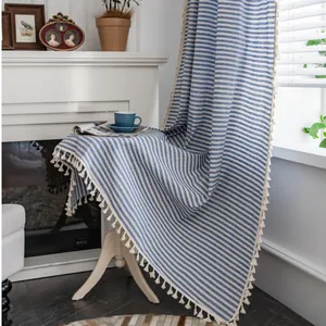 Close-up of blue and white striped cotton linen fabric with delicate white fringe edge