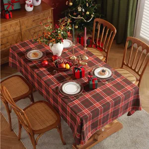 Detail van het rood-groene geruite kersttafelkleed op een feestelijke houten eettafel