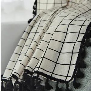 Detail of Nordic grey-white geometric cotton linen fabric with elegant black tassels