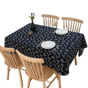 Blue rectangular cotton linen tablecloth with white floral pattern on a wooden table