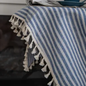 Close-up of blue and white striped cotton linen fabric with elegant white tassel edge