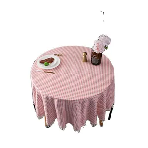 Pink and white checkered round tablecloth with tassel fringe and elegant dining table set