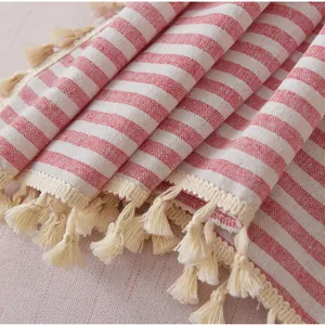 Detail of red striped linen curtain fabric with handmade beige tassel trim edge